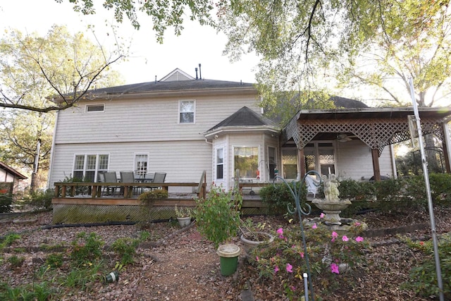 back of house with ceiling fan and a wooden deck