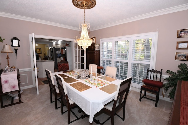 carpeted dining room featuring a chandelier, a textured ceiling, and crown molding