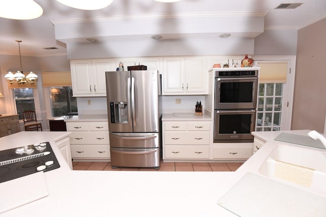 kitchen with white cabinetry, a notable chandelier, decorative light fixtures, light tile patterned floors, and appliances with stainless steel finishes