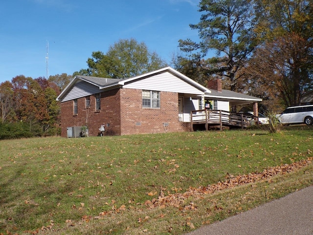 view of side of property with a yard, central AC, and covered porch