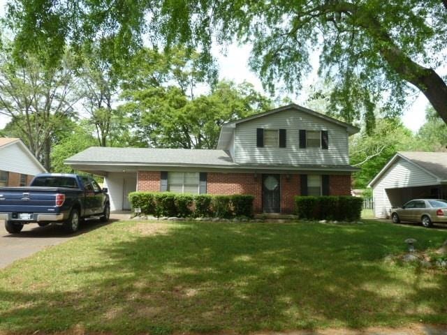 view of front of home with a carport and a front yard