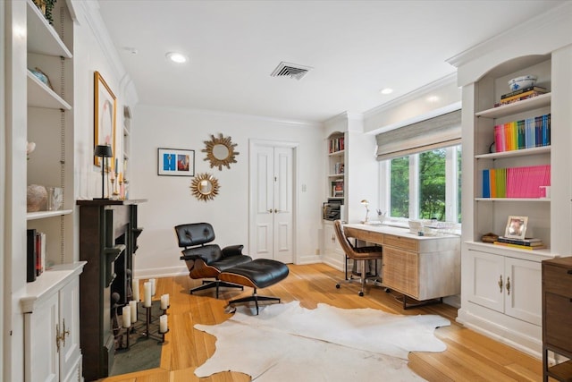 office area with light wood-type flooring and crown molding