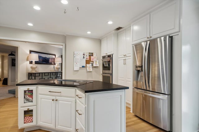 kitchen with a kitchen island, white cabinetry, appliances with stainless steel finishes, and light hardwood / wood-style flooring