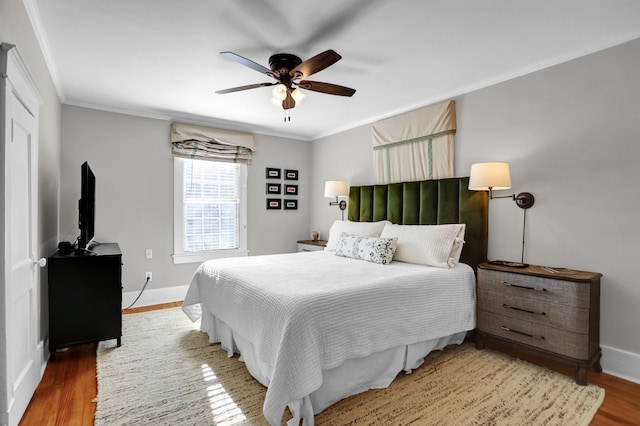 bedroom with hardwood / wood-style flooring, ceiling fan, and ornamental molding