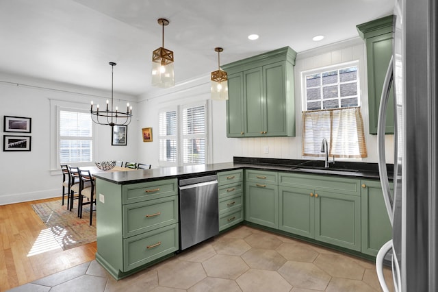 kitchen with green cabinets, light hardwood / wood-style flooring, appliances with stainless steel finishes, decorative light fixtures, and kitchen peninsula