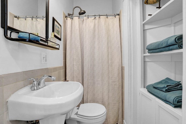 bathroom with backsplash, toilet, sink, and a shower with shower curtain