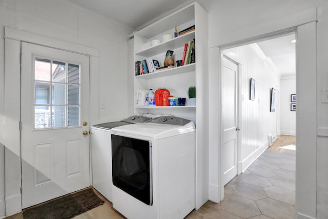 laundry area with light tile patterned floors, washer and clothes dryer, and crown molding