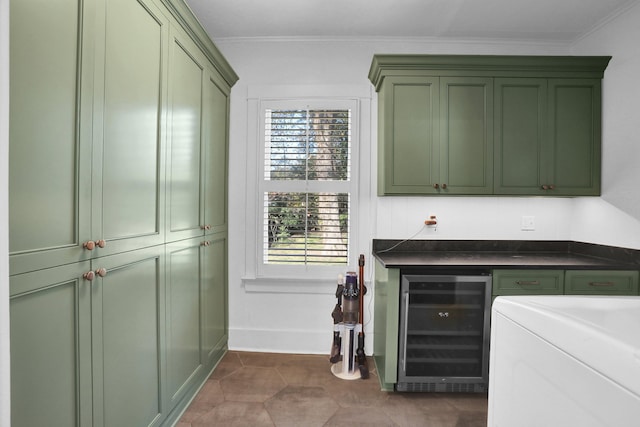 interior space with dark tile patterned floors, wine cooler, green cabinetry, and ornamental molding