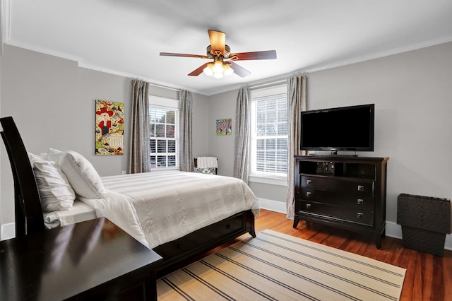 bedroom featuring dark hardwood / wood-style flooring, multiple windows, crown molding, and ceiling fan