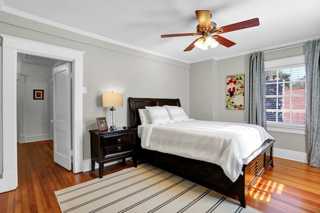 bedroom featuring ceiling fan, wood-type flooring, and ornamental molding