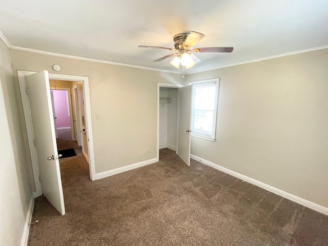 unfurnished bedroom with dark colored carpet, ceiling fan, crown molding, and a closet