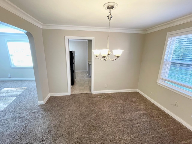 unfurnished dining area with carpet flooring, a wealth of natural light, an inviting chandelier, and ornamental molding