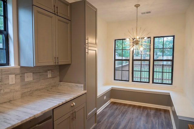 kitchen featuring decorative backsplash, dark hardwood / wood-style flooring, pendant lighting, a notable chandelier, and gray cabinets