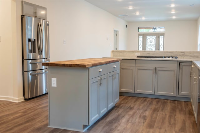 kitchen featuring butcher block counters, dark hardwood / wood-style flooring, gray cabinetry, and stainless steel refrigerator with ice dispenser