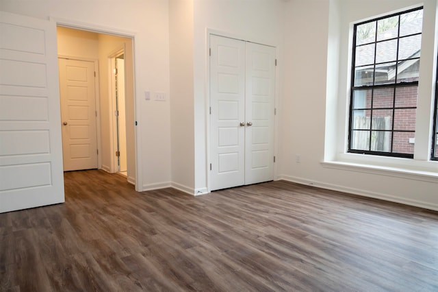 unfurnished bedroom featuring dark hardwood / wood-style flooring and a closet