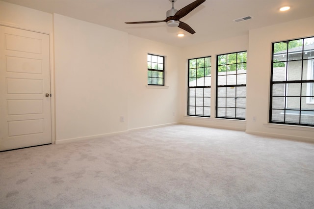 spare room featuring light carpet and ceiling fan