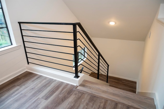 stairs with hardwood / wood-style flooring and vaulted ceiling