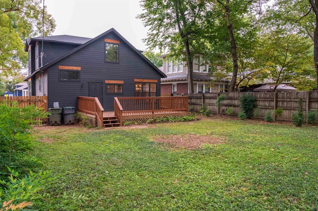 back of house featuring a lawn and a wooden deck