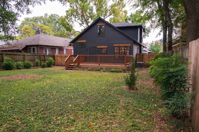 back of house with a deck, cooling unit, and a lawn