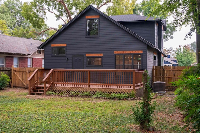 back of property with a lawn, central AC unit, and a deck