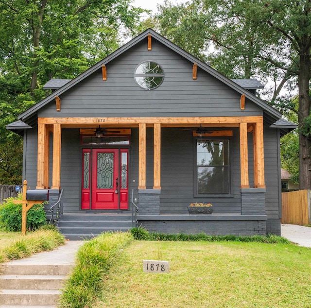 bungalow-style house featuring covered porch and a front lawn