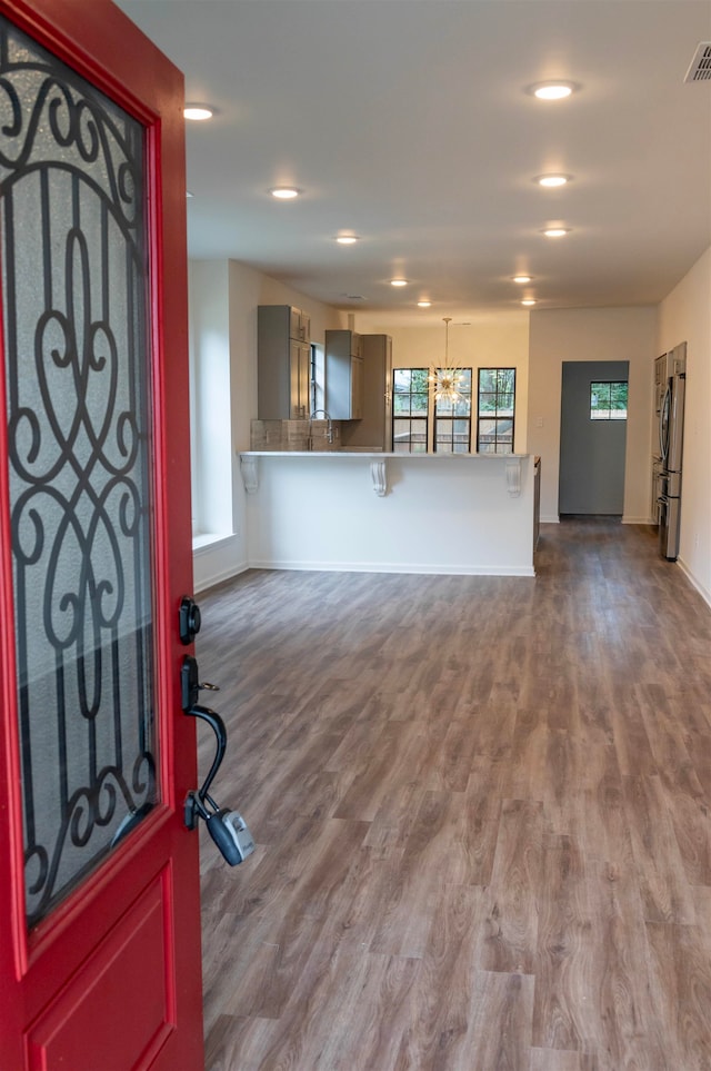 entryway with hardwood / wood-style flooring and a notable chandelier