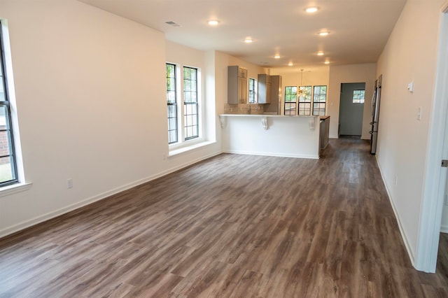 unfurnished living room with plenty of natural light and dark wood-type flooring