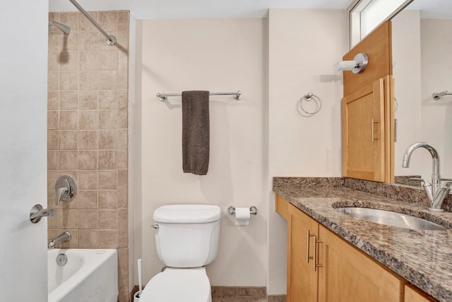 full bathroom with vanity, tiled shower / bath combo, and toilet