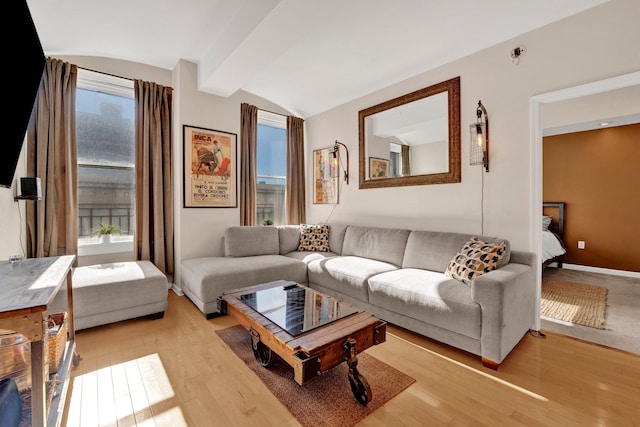 living room with vaulted ceiling with beams, light hardwood / wood-style flooring, and plenty of natural light