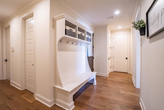 mudroom with wood-type flooring and crown molding