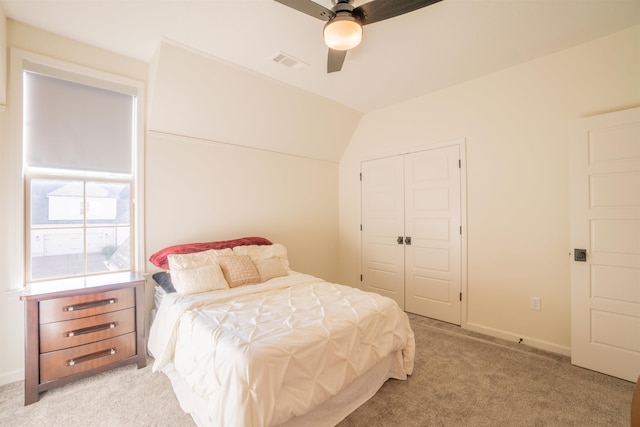 carpeted bedroom with a closet, ceiling fan, and lofted ceiling