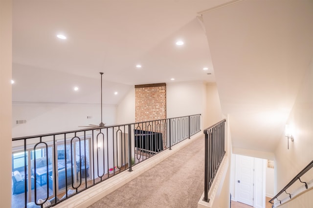 hall featuring light colored carpet and lofted ceiling