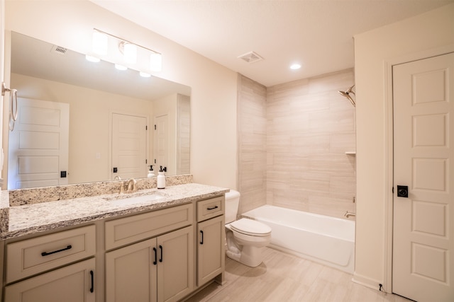 full bathroom with vanity, tiled shower / bath combo, and toilet