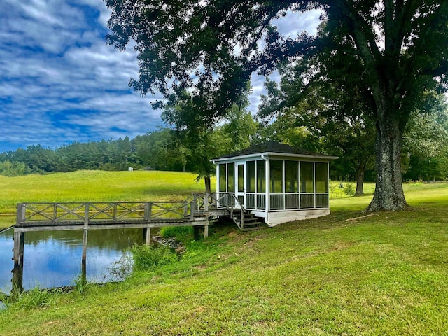 dock area with a lawn and a water view