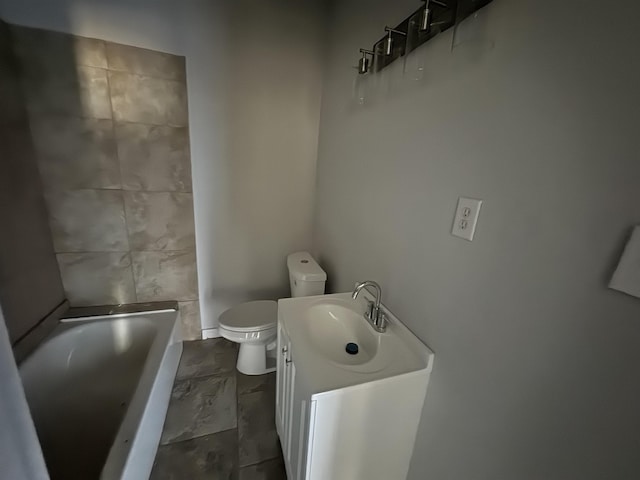 bathroom featuring a washtub, vanity, and toilet