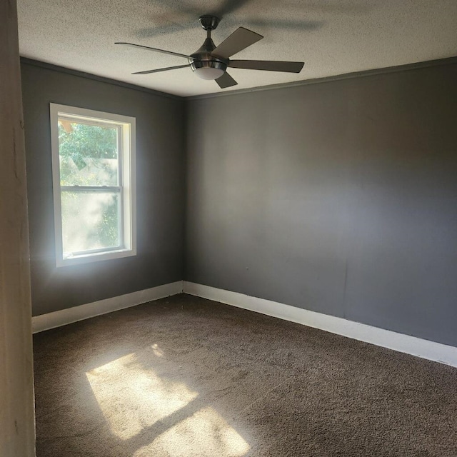 carpeted spare room with a textured ceiling and ceiling fan