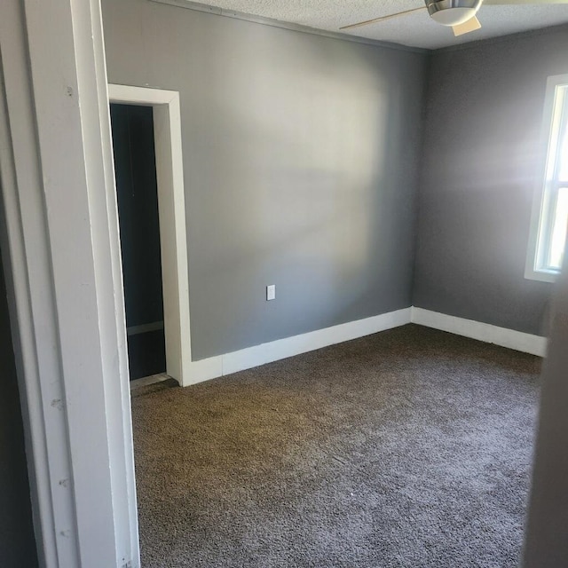 carpeted empty room featuring ceiling fan and a textured ceiling