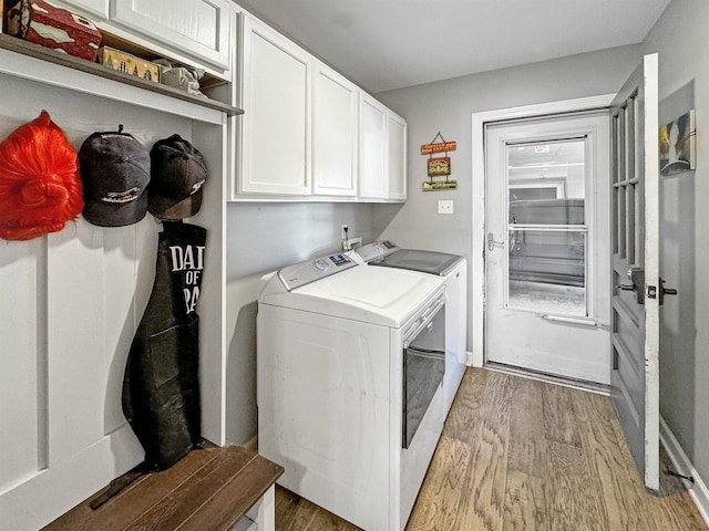 laundry area featuring washer and dryer, cabinets, and light hardwood / wood-style floors