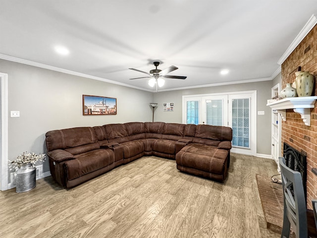 living room with a fireplace, light wood-type flooring, ceiling fan, and ornamental molding