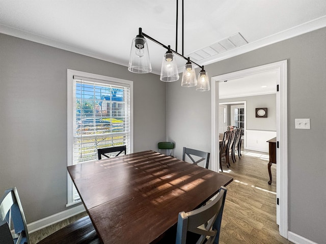 dining area featuring hardwood / wood-style flooring and ornamental molding