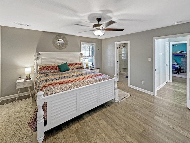 bedroom with hardwood / wood-style flooring, ceiling fan, and ensuite bath