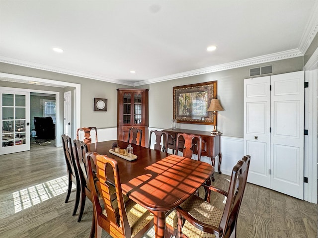 dining space with french doors, crown molding, and dark wood-type flooring