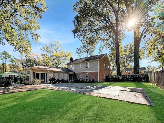 back of property with a yard and a patio area