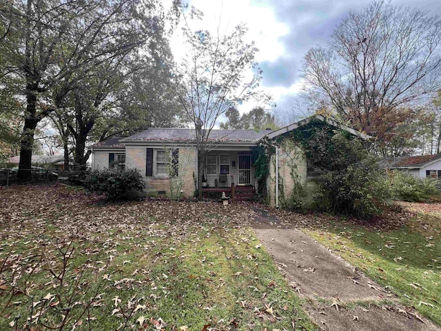 rear view of property featuring a porch and a yard