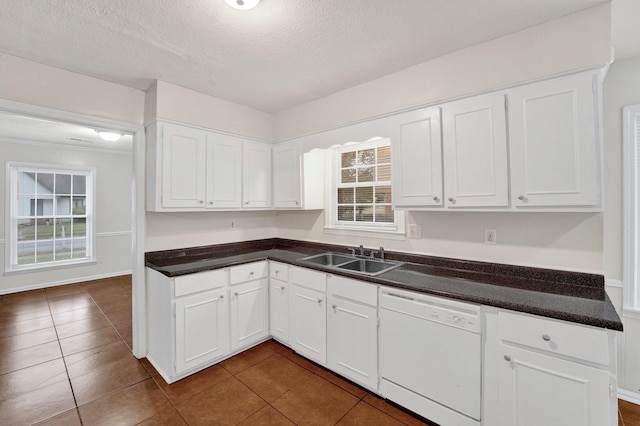 kitchen featuring white dishwasher, white cabinetry, a wealth of natural light, and sink