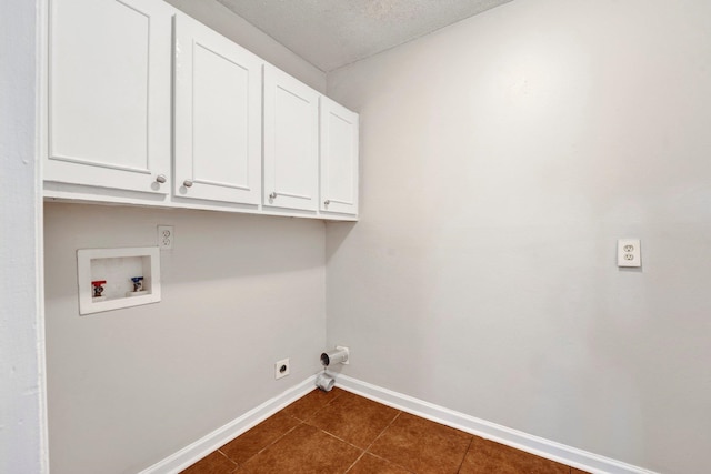 washroom with cabinets, hookup for a washing machine, a textured ceiling, dark tile patterned floors, and electric dryer hookup