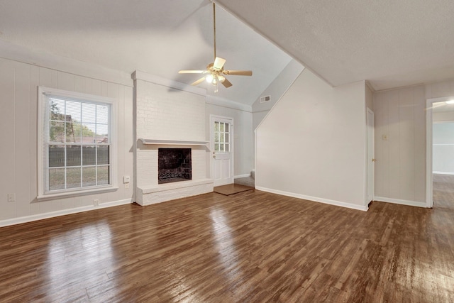 unfurnished living room featuring dark hardwood / wood-style flooring, a brick fireplace, a textured ceiling, ceiling fan, and high vaulted ceiling