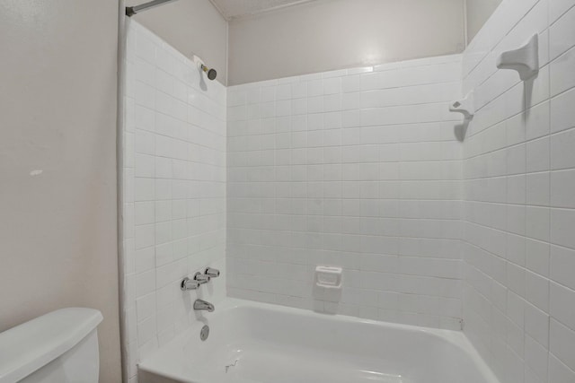 bathroom with tiled shower / bath combo and toilet