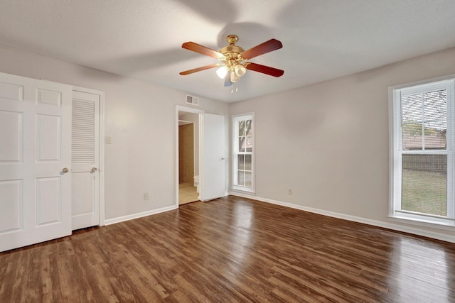 unfurnished bedroom with ceiling fan, dark hardwood / wood-style floors, and a textured ceiling