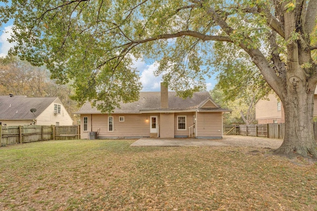 rear view of house with a patio area, a yard, and central AC